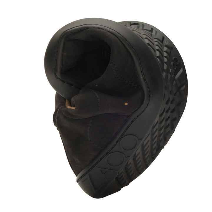 The QOMFY Wide Black shoe from ZAQQ made of suede is shown folded to highlight its flexibility, with the structured ZAQQ SNEAKER sole. This black shoe is lightweight and flexible, making it an ideal, versatile barefoot shoe for everyday use.