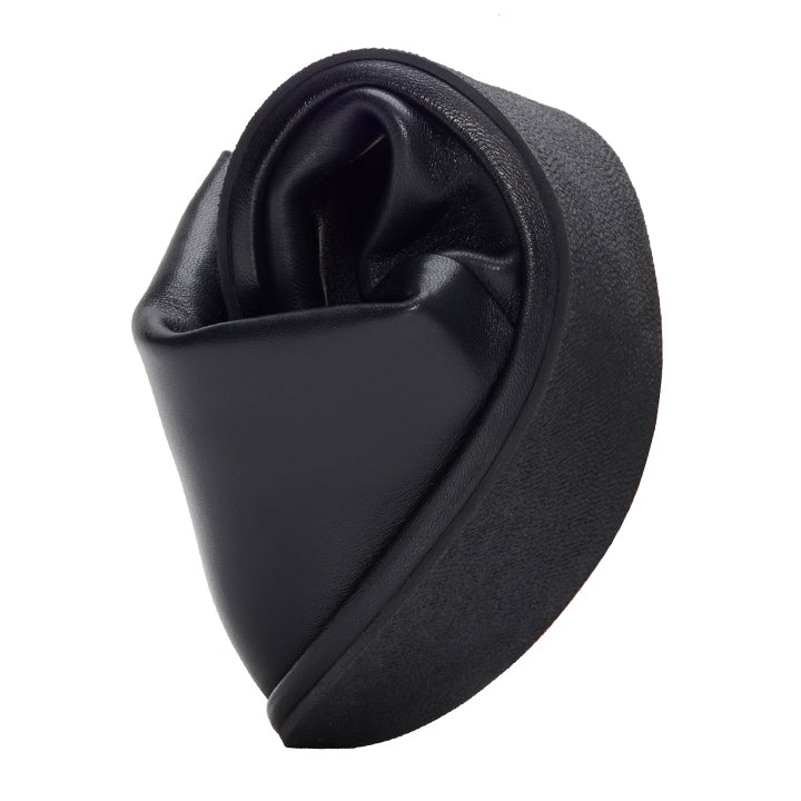 The QOURTNEY Black from ZAQQ is a leather sculpture with a twisted, abstract shape reminiscent of a heart-shaped bow. It features a smooth, glossy texture that contrasts with the matte finish on the back for a modern and artistic look reminiscent of an elegantly crafted ankle boot.