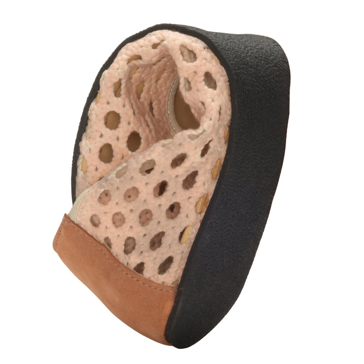 Close-up of the heel of the TWIST Nude climbing shoe, highlighting its textured black rubber, with a perforated lining that exudes ballerina-like elegance and a brown suede patch at the bottom. The design emphasizes grip and comfort, similar to the precision found in ZAQQ-shoes.