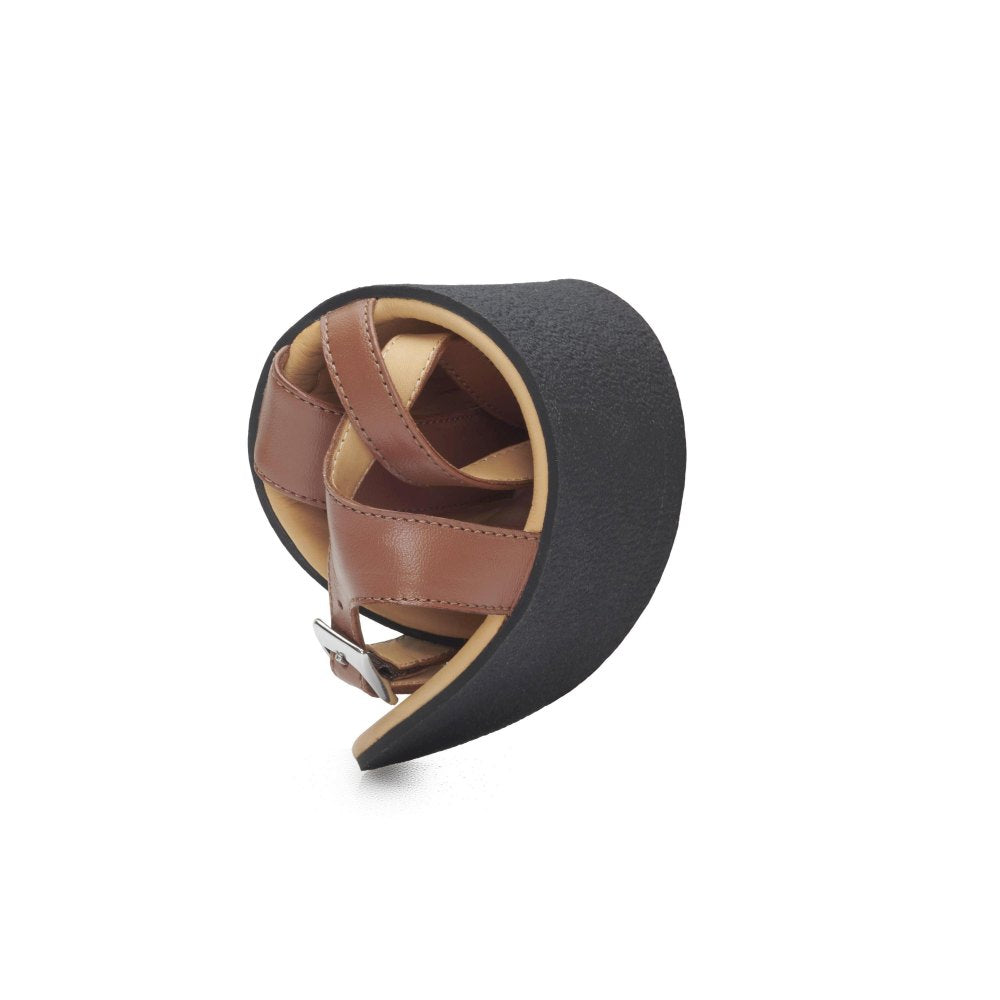 A pair of QEE cognac sandals from ZAQQ, creatively designed in a spiral shape with a buckle. They feature cushioned rubber soles for ultimate comfort and rest on a simple white background.