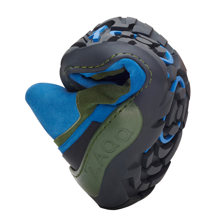 Close-up of a flexible spirally rolled one ZAQQ SQOUT Blue Green Waterproof outdoor shoes. It features a sturdy black and blue sole with a green and blue fabric upper. The brand name ZAQQ is visible on the side and highlights the durable TERRA sole.