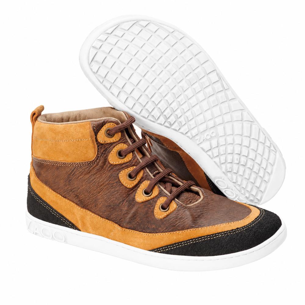Madinga ZAQQ CINQO Brown High-Top sportbačių pora rudos ir oranžinės spalvos su juodais akcentais ir baltais padais iš minkštos nappa odos. Vienas batas stovi vertikaliai, o kitas guli šonu, pabrėžiant struktūrizuotą pado dizainą, kuris perteikia basos kojos batų komfortą.