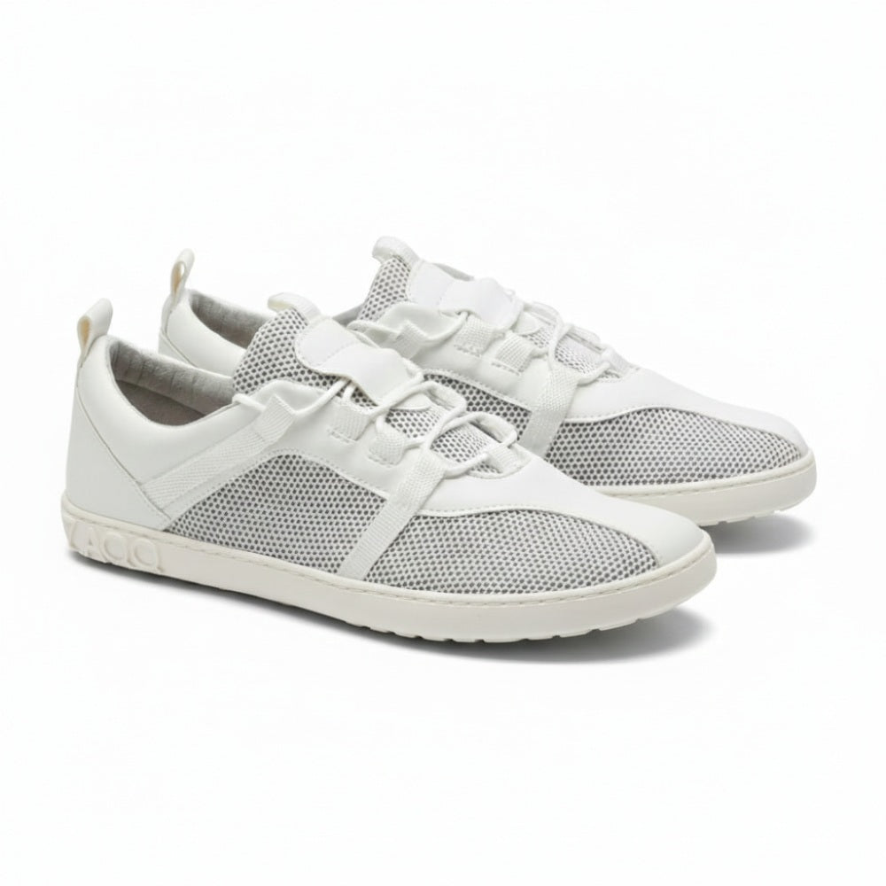 Ein Paar MCQARTER White-Sneaker von ZAQQ verfügt über atmungsaktives Meshgewebe und Schnürsenkel auf einem sauberen weißen Hintergrund, ergänzt durch eine graue Sohle mit eingeprägtem Markennamen in der Nähe der Ferse. Diese Schuhe zeichnen sich durch ein minimalistisches und sportliches Design aus.