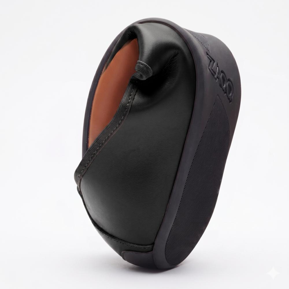 Der QARMA Black von ZAQQ aus zerknittertem, schwarzem, lederähnlichem Material erinnert an die elegante Anmut einer Ballerina. Seine strukturierte Oberfläche weist komplexe gefaltete Formen auf, die sich wunderschön von einem schlichten weißen Hintergrund abheben.