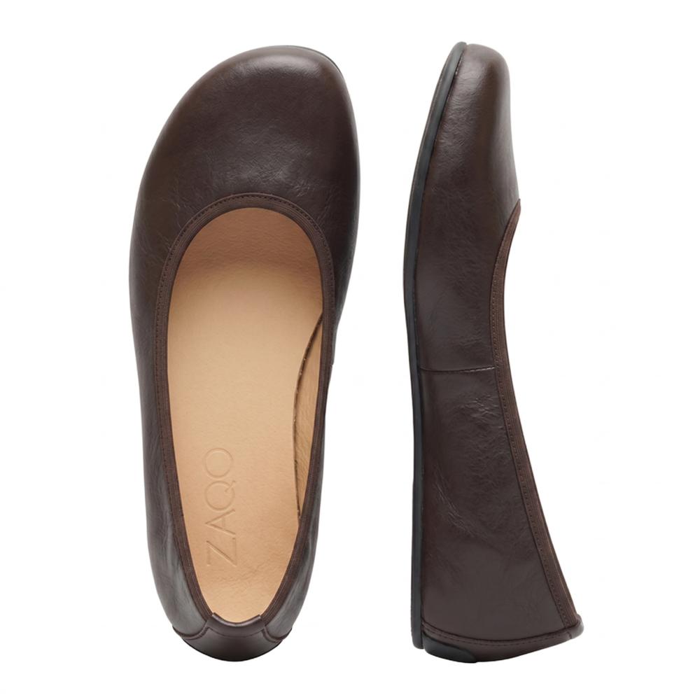 Gezeigt wird ein Paar schlichte dunkelbraune Ballerinas aus luxuriösem Nappaleder. Ein Schuh steht aufrecht, während der andere flach liegt und den aufgedruckten Markennamen ZAQQ im Inneren zeigt. Mit ihrer glatten Textur und dem abgerundeten Zehendesign strahlen diese QARMA Barfuß-Ballerinas sowohl Eleganz als auch Komfort aus.