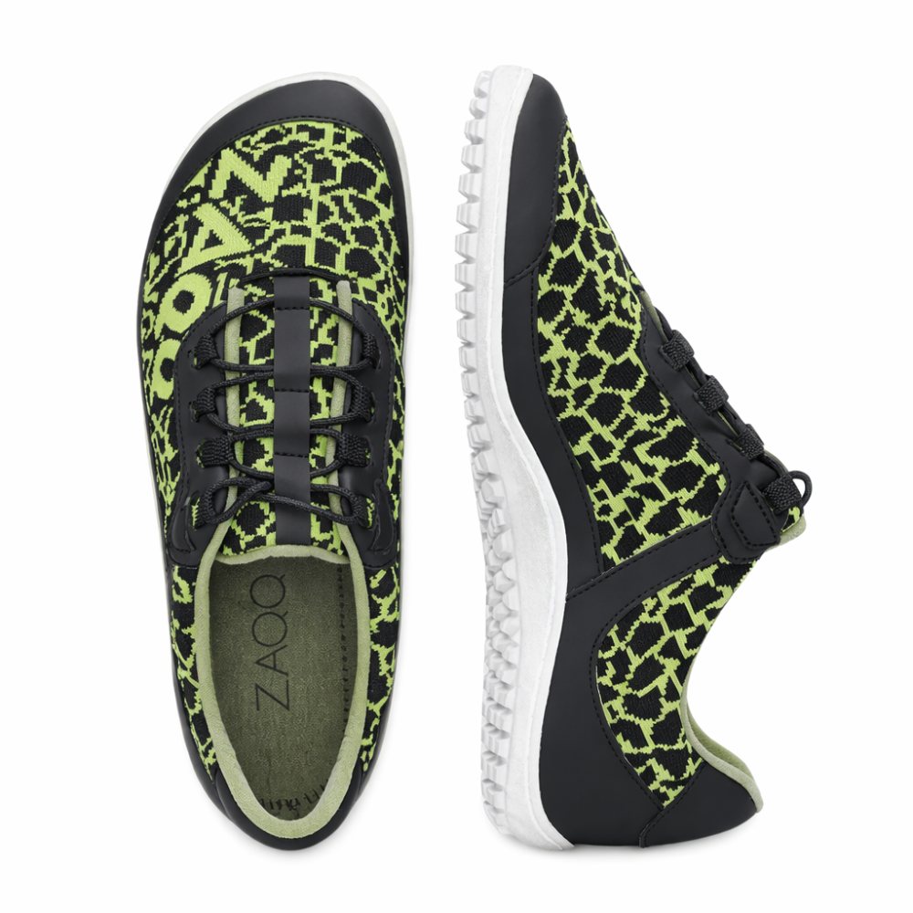 Die QINGSTON Green Sneaker von ZAQQ sind in einer Draufsicht und einer Seitenansicht abgebildet und zeichnen sich durch ein schwarz-grünes Muster aus. Diese Schuhe bestehen aus veganen Materialien und bieten ein leichtes, atmungsaktives Design mit einer flexiblen Sohle und einem Schnürverschluss. Der Markenname ZAQQ ist auf der Innensohle abgebildet.