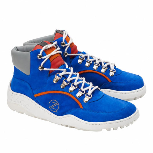 Die TERRAQ Azure Waterproof Sneaker von ZAQQ sind leuchtend blaue High-Tops mit grauen Knöchelbündchen und rot-orangen Akzenten. Sie sind als Outdoorschuhe konzipiert und verfügen über weiße Schnürsenkel mit silbernen Ösen sowie eine markante dicke weiße Sohle, die für optimale Traktion sorgt.