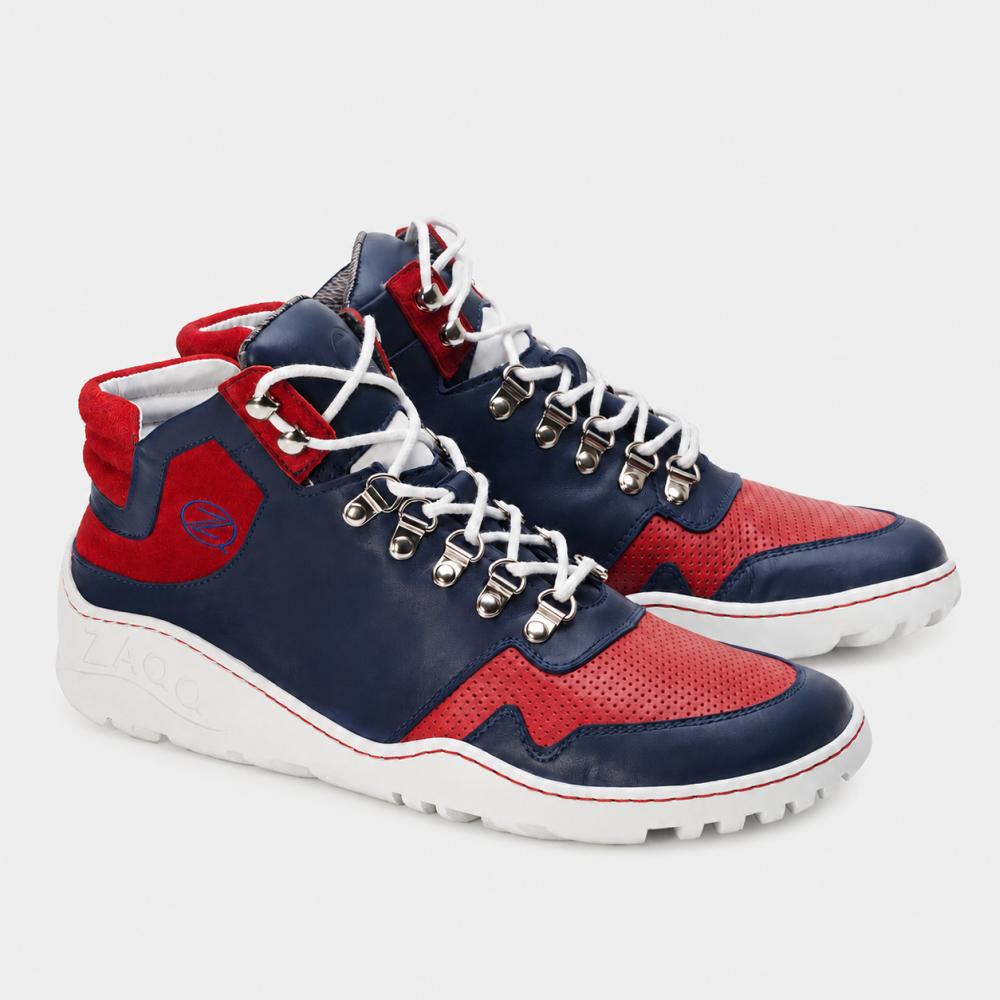 Wir präsentieren die wasserdichten VAQATION Red High-Top-Sneaker von ZAQQ. Diese stylischen Schuhe bestechen durch ein leuchtendes Rot, Marineblau und Weiß und sind mit der charakteristischen ZAQQ TERRA Sohle ausgestattet. Sie verfügen über weiße Schnürsenkel, Metallösen und perforierte Details auf den roten Abschnitten. Die weiße Außensohle ist mit strukturierten Griffen versehen, um die Traktion zu verbessern.